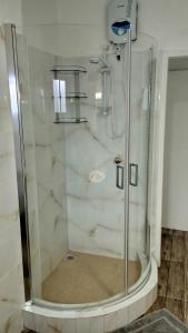 a shower with a glass door in a bathroom at Dovass Self Catering Apartments in Takamaka