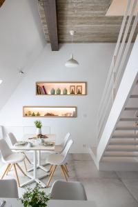 a dining room with a table and chairs and stairs at B&B Summertime in Koksijde