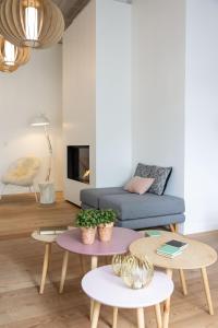 a living room with a couch and tables at B&B Summertime in Koksijde