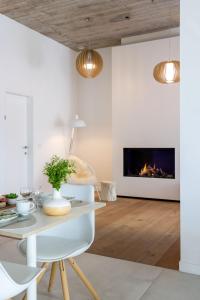 a living room with a table and a fireplace at B&B Summertime in Koksijde