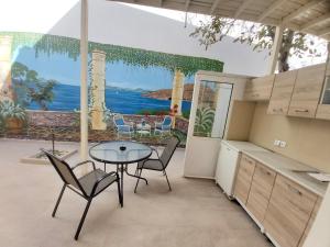 a kitchen with a table and chairs and a view of the ocean at Antonios 1 in Matala