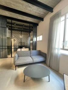 ein Wohnzimmer mit einem Sofa und einem Tisch in der Unterkunft דירה מדהימה ניו יורק בתל אביב in Tel Aviv