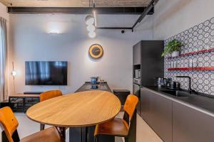 eine Küche mit einem Holztisch sowie einem Tisch und Stühlen in der Unterkunft דירה מדהימה ניו יורק בתל אביב in Tel Aviv