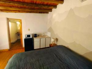 1 dormitorio con 1 cama y cocina pequeña en Aires de Coria con parking en Chacras de Coria