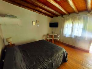 1 dormitorio con cama, mesa y ventana en Aires de Coria con parking en Chacras de Coria