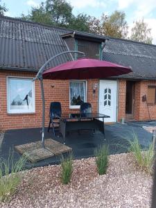 patio ze stołem i fioletowym parasolem w obiekcie Ferienwohnung Auetal 