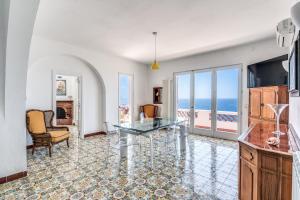 sala de estar con mesa de cristal y vistas al océano en Villa Dafne, en Massa Lubrense