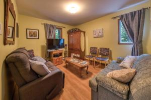 a living room with two couches and a tv at Le Domaine de l'Étang in Frampton