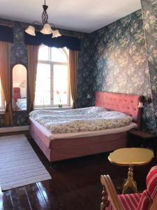 a bedroom with a bed in a room with floral wallpaper at Cafebrumman in Neksø