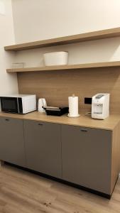eine Küchentheke mit zwei Mikrowellen und einer Mikrowelle in der Unterkunft fragilerooms in Dolo