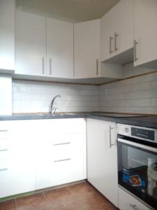 a kitchen with white cabinets and a sink and an oven at Bibi Apartment in Martin