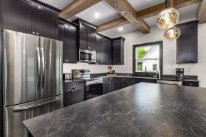 eine Küche mit schwarzen Schränken und einem Kühlschrank aus Edelstahl in der Unterkunft Luxury Lakefront Villa - FREE HUGE Pool/Hot Tub - MINI GOLF in Kimberling City