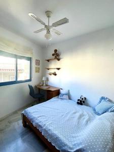 sypialnia z łóżkiem, biurkiem i wentylatorem sufitowym w obiekcie Sunny 2-bedroom apartment with sea view w mieście Castell de Ferro