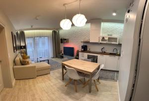 a kitchen and living room with a table and a couch at Apartament Byka in Poznań