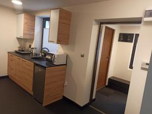 a small kitchen with a sink and a microwave at Pod Domem in Grodzisk Mazowiecki