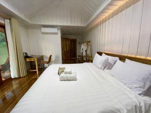 1 dormitorio con 1 cama blanca grande y toallas. en Nongkhiaw The Float House, en Nongkhiaw