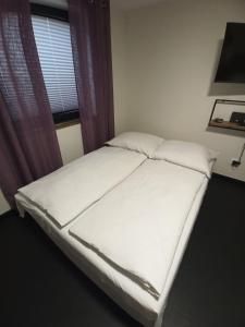 - un lit blanc dans une chambre avec fenêtre dans l'établissement Pod Domem, à Grodzisk Mazowiecki