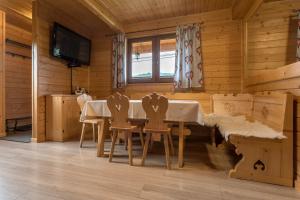 uma sala de jantar com uma mesa e cadeiras num camarote em Domki Pienińskie em Szczawnica