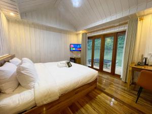 a bedroom with a bed with a television and a desk at Nongkhiaw The Float House in Nongkhiaw