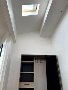 een kamer met een plafond met een raam en een plank bij Loft lumineux en centre ville in Sète