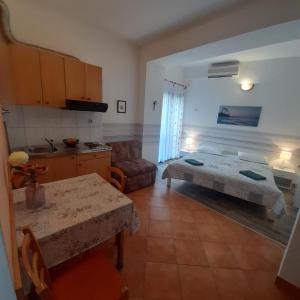 a bedroom with a bed and a table and a kitchen at Beach pearl 1 in Jesenice