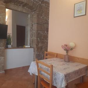 a dining room with a table and a stone wall at Beach pearl 1 in Jesenice
