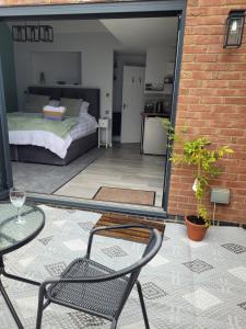 a patio with a bed and a table and chairs at The Nest at Deneside in Cinderford