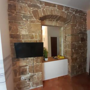 a room with a stone wall with a tv on it at Beach pearl 1 in Jesenice