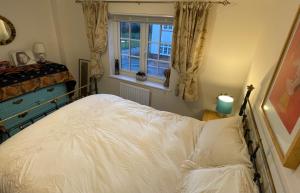 a bedroom with a bed and a window at Rose Cottage 