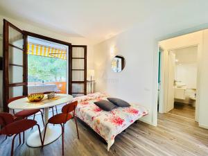 um quarto com uma cama, uma mesa e cadeiras em Mercury Apartment - Vista Lago con Piscina em Sirmione
