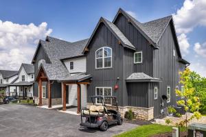 ein schwarzes Haus mit einem Golfwagen davor in der Unterkunft Luxury Lakefront Villa - Over 30 FREE amenities included! in Kimberling City