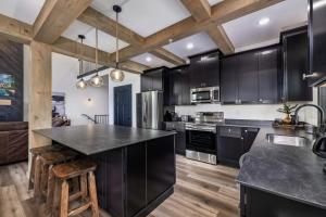 eine Küche mit schwarzen Schränken und einer schwarzen Arbeitsplatte in der Unterkunft Luxury Lakefront Villa - Over 30 FREE amenities included! in Kimberling City