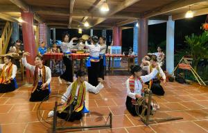 un groupe d'enfants jouant une danse dans une pièce dans l'établissement LePont Mu Waterfall Bungalow, à Hòa Bình