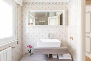 La salle de bains est pourvue d'un lavabo et d'un miroir. dans l'établissement T-House Fontana di Trevi, à Rome