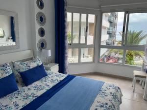 プエルト・デ・ラ・クルスにあるRosmaryのベッドルーム1室(青いシーツと窓付)