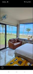 Lang SuanにあるBaan Be Beachのベッドルーム(ベッド1台、ソファ、大きな窓付)