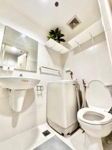 Baño blanco con aseo y lavamanos en Sea Residences Apartment by Kevin Alano, en Manila