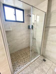 a shower with a glass door in a bathroom at Pi-thon In House in Yujing