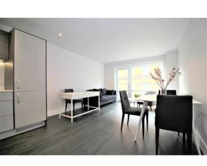 a living room with a table and chairs and a couch at Rent Luxuri - Luxury 2 bed Apartment in Leicester