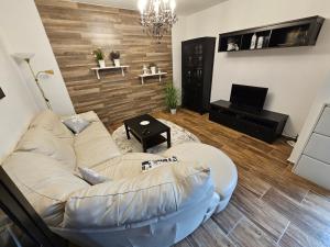 sala de estar con sofá blanco y TV en Apartmán Lovča, 