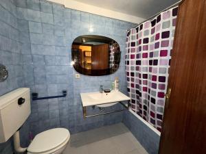 La salle de bains est pourvue de toilettes, d'un lavabo et d'un miroir. dans l'établissement Quarto privativo perto Centro Porto, à Porto