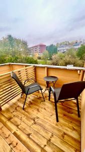 eine Terrasse mit 2 Stühlen und einem Tisch auf einer Terrasse in der Unterkunft Sleep with the stars in Oslo