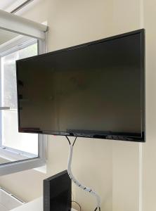 a large flat screen tv hanging on a wall at Maisonnette dans jardin partagé in Colombes