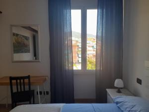 a bedroom with a bed and a window with a desk at Casa Marty in Rapallo