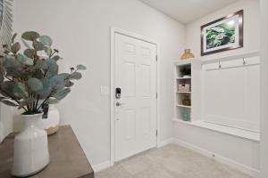 a room with a white door and a vase with a plant at NEW to Market New Construction 5 Bed Retreat In World Famous Windsor Island in Davenport