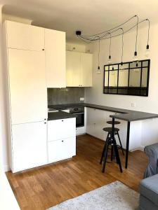 a kitchen with white cabinets and a table in a room at Cute Apartment In The City Center , 2-Beds , Wi-Fi - by HIK Apartments in Warsaw