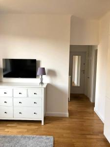a white dresser with a television on top of it at Cute Apartment In The City Center , 2-Beds , Wi-Fi - by HIK Apartments in Warsaw