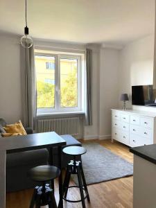 a kitchen with a table and two stools in a room at Cute Apartment In The City Center , 2-Beds , Wi-Fi - by HIK Apartments in Warsaw