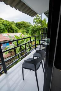 balkon z 2 krzesłami i widokiem w obiekcie The Bright House, Koh Phi Phi w Ko Phi Phi