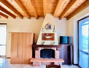 uma lareira numa sala de estar com tecto em madeira em Rea Apartment - 500 m dal Lago con Piscina em Sirmione